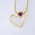9ct yellow gold heard made from a strip with Ruby set rubover. the chain gos through both the setting and the ribbon heart