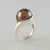 sterling silver forged ring with large cook islands black pearl rivited between 2 ring halves.