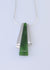 tapered greenstone bar hanging freely on a chain between silver bars on either side.