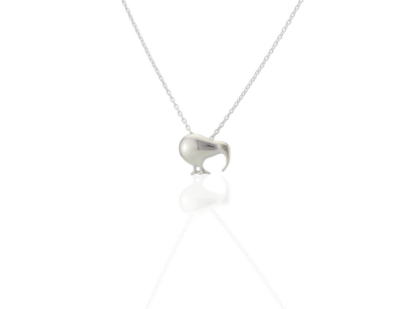 A silver pendant necklace featuring a small, stylized kiwi bird silhouette on a delicate chain, shown against a clean white background with a soft reflection below.